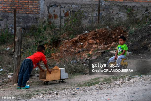 Boys play in the poor neighbourhood of Nueva Capital, on the outskirts of Tegucigalpa, on May 13, 2018. - Missionaries from the United States who met...