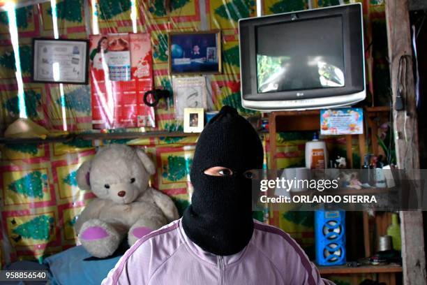 Person wearing a balaclava offers an interview to AFP in the poor neighbourhood of Nueva Capital, on the outskirts of Tegucigalpa, on May 13, 2018. -...