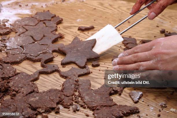 Backen, Kekse backen, Plaetzchen backen, Weihnachtsplaetzchen, Weihnachtsgebaeck. Dunkler Teig wird ausgestochen