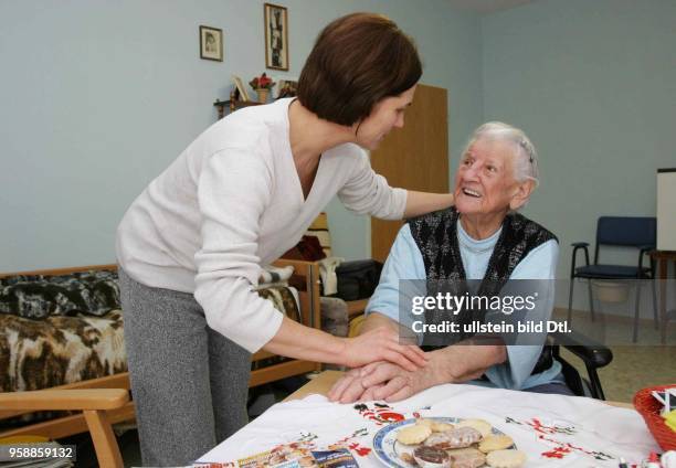 Deutschland, Brandenburg, Rentnerin mit einer jungen Pflegerin in ihrem Zimmer im Pflegeheim in Letschin