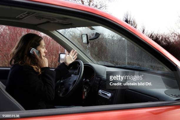 Deutschland - Frau telefoniert mit Handy beim Auto fahren