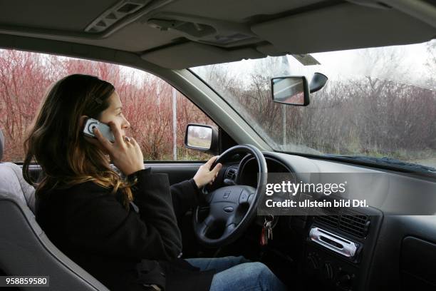 Deutschland - Frau telefoniert mit Handy beim Auto fahren