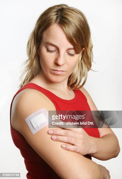 Young woman with a plaster at her arm -