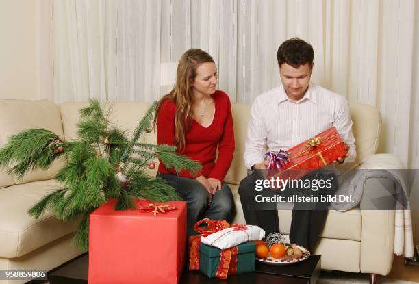 Weihnachten, Weihnachtsgeschenke, Junges Paar bei der Bescherung -