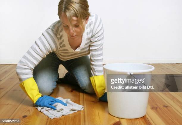 Young woman is cleaning the floor -