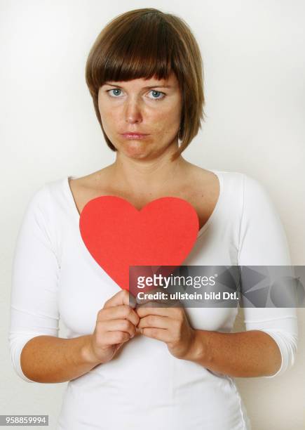 Symbolic photo love, divorce, parting, single, woman with a red heart -