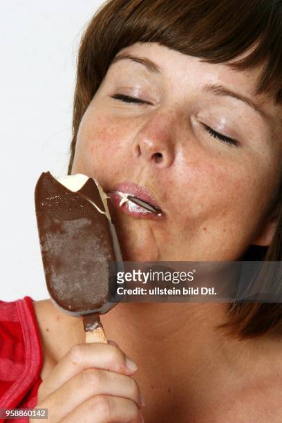 Germany; young woman eating icecream / iced-lolly - 2007