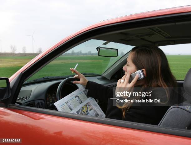 Deutschland - Frau telefoniert mit Handy beim Auto fahren