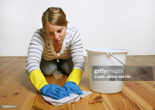 Young woman is cleaning the floor -