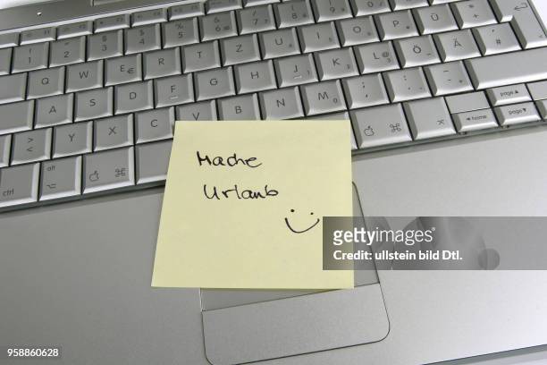 Post-It note "on holiday" on a laptop