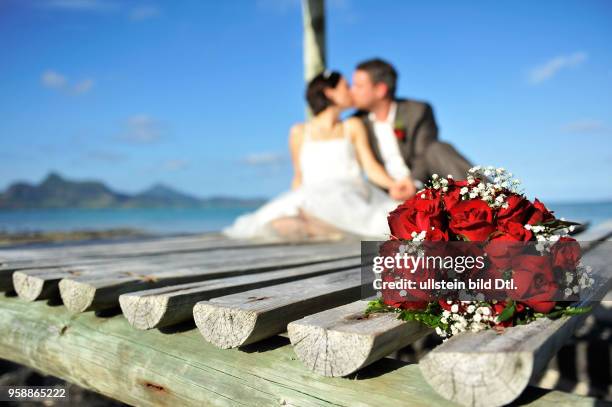 Ein Brautpaar kuesst sich am Strand des Preskil Beach Resort von Mauritius