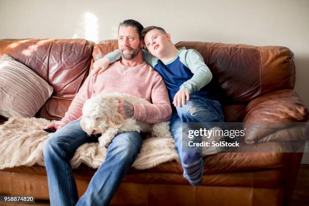 ontspannen op de sofa thuis - boy at television stockfoto's en -beelden