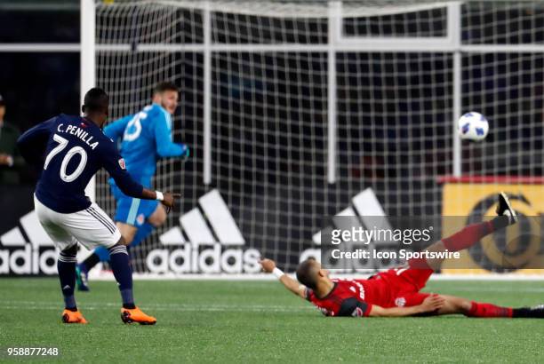New England Revolution forward Cristian Penilla watches his second goal of the match beat Toronto FC defender Jason Hernandez and Toronto FC...