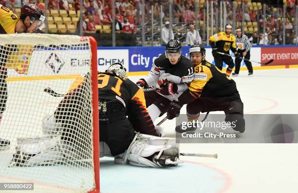 Niklas Treutle of Team Germany, Jean-Gabriel Pageau of Team Canada and Moritz Mueller of Team Germany during the IIHF World Championship game between...