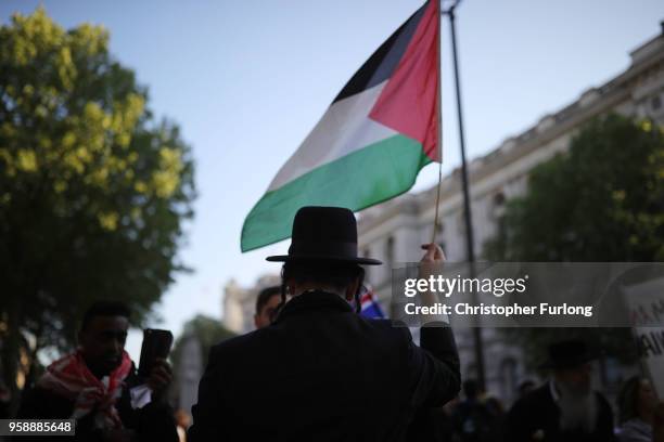 An orthodox Jew holds up a Palestinian flag in support as people take part in a protest against Israel in Whitehall on May 15, 2018 in London,...