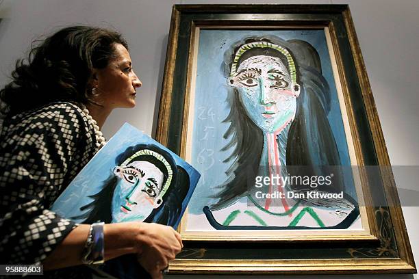 Christie's employee stands beside a work entitled 'Tete de Femme' by Pablo Picasso on January 20, 2010 in London, England. The piece, with an...