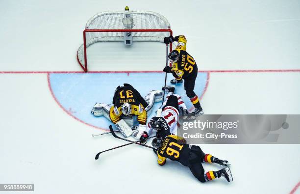 Niklas Treutle of Team Germany, Jean-Gabriel Pageau of Team Canada, Moritz Mueller and Patrick Hager of Team Germany during the IIHF World...