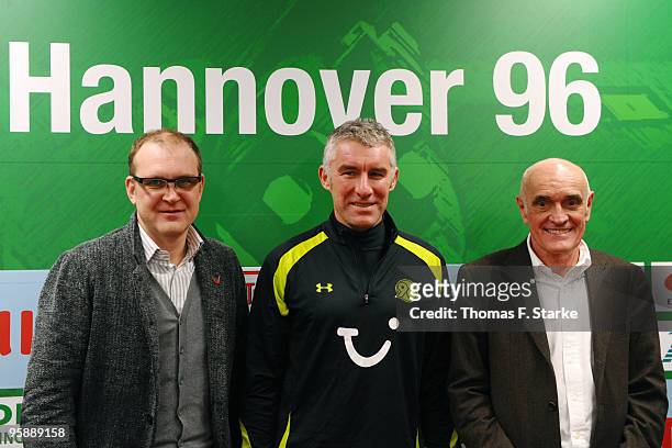 Sports director Joerg Schmadtke, new head coach Mirko Slomka and president Martin Kind of Hannover 96, pose for photographers after the press...