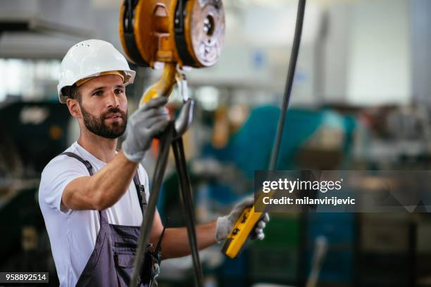 worker in factory using lifting beam - construction cranes stock pictures, royalty-free photos & images