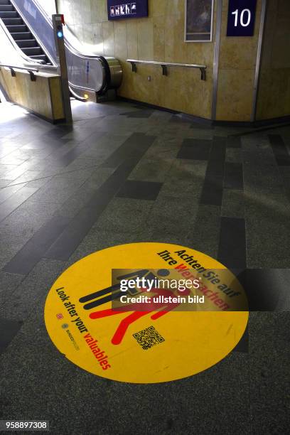 Grosswarnung vor Taschendieben auf dem Berliner Ostbahnhof mit Aufkleber am Boden.