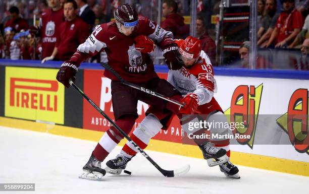 Kristians Rubins of Latvia and Nichlas Hardt of Denmark battle for the puck during the 2018 IIHF Ice Hockey World Championship Group B game between...