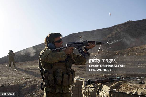 An Australian soldier of Omlet-c company tries an AK47 rifle used by the Afghan soldiers during practice firing at the forward operating base in...