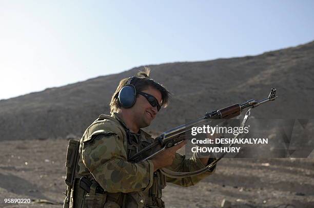 An Australian soldier of Omlet-c company tries an AK47 rifle used by the Afghan soldiers during practice firing at the forward operating base in...