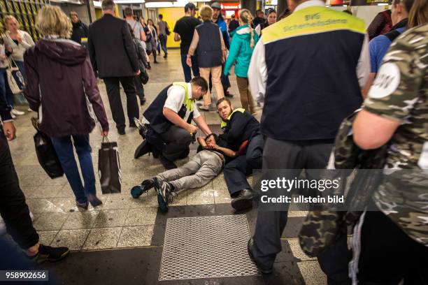 Deutschland Germany Berlin Personal des BVG-Sicherheitsdienstes halten in der Unterführung des Bahnhof Zoo einen Mann auf dem Boden fest.