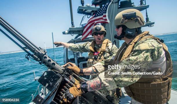 Quarter Master 2nd Class Patrick Riley speaking to Quarter Master Seaman Kolton Kelly during a simulated small boat attack exercise, San Diego, May...