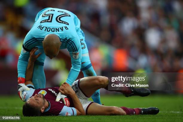 Conor Hourihane of Aston Villa goes down injured and is helped by Darren Randolph of Middlesbrough during the Sky Bet Championship Play Off Semi...