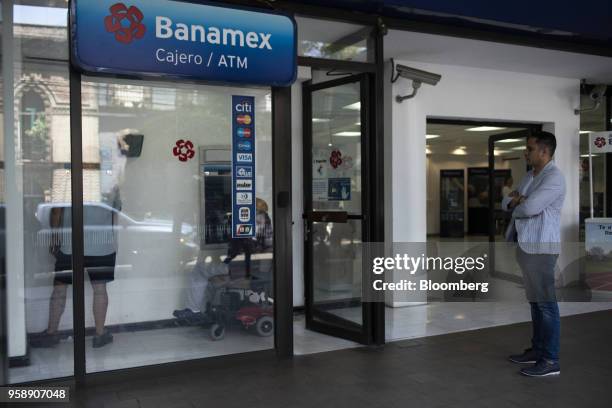 Customer stands in line to use an automatic teller machine at a Banco Nacional de Mexico SA bank branch in Mexico City, Mexico, on Tuesday, May 15,...