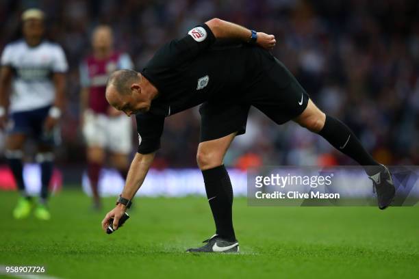 Referee Mike Dean sprays a line of paint during the Sky Bet Championship Play Off Semi Final second leg match between Aston Villa and Middlesbrough...