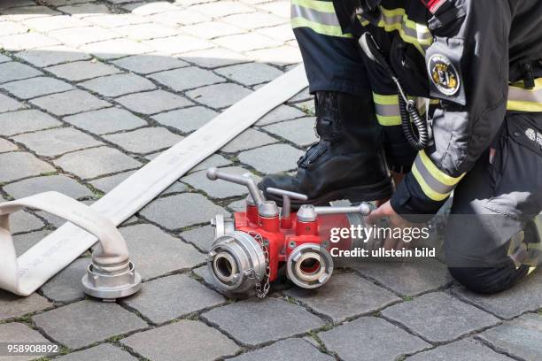 Feuerwehrmann beim Abkoppeln eines Wasserverteilers - Einsatz für die Berliner Feuerwehr bei einem vermutlichen Wohungsbrand in Berlin-Prenzlauer Berg