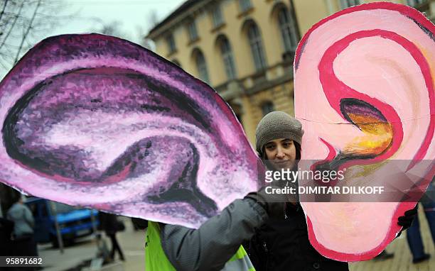 Participants hold cartoon ears during a protest against a bill allowing round-the-clock surveillance of the Internet and mobile communications of...