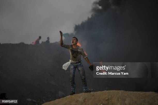 Palestinian man taunts his fellow protester about not having enough courage to move forward, in Buriej, near Deir al-Bala, Gaza, on May 15, 2018.