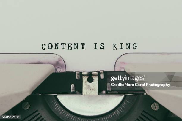 content is king text typed on vintage typewriter - contento foto e immagini stock