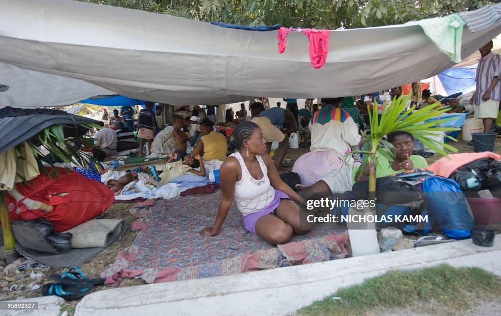 Haitians sit on the Place St. Pierre, wh
