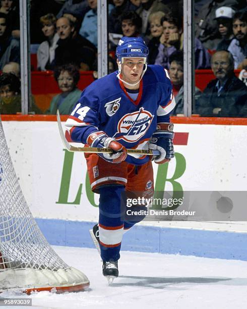 Stu Barnes of the Winnipeg Jets skates behind the net in search for the puck against the Montreal Canadiens in the early 1990's at the Montreal Forum...