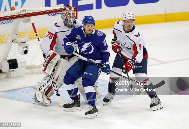 Yanni Gourde of the Tampa Bay Lightning takes up position in front of goalie Braden Holtby of the Washington Capitals as Dmitry Orlov defends during...