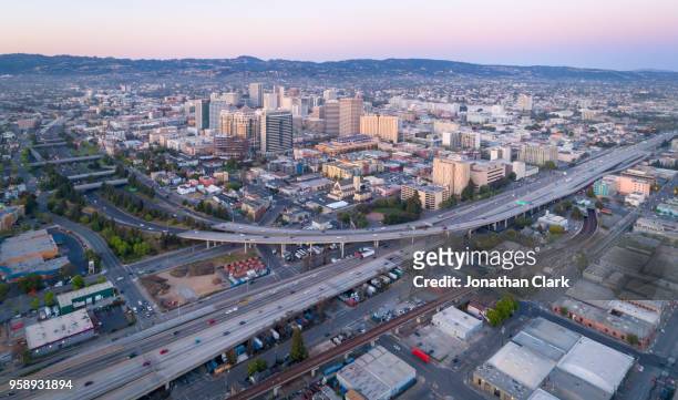 aerial: oakland city skyline at sunset. california, usa - oakland californië stockfoto's en -beelden