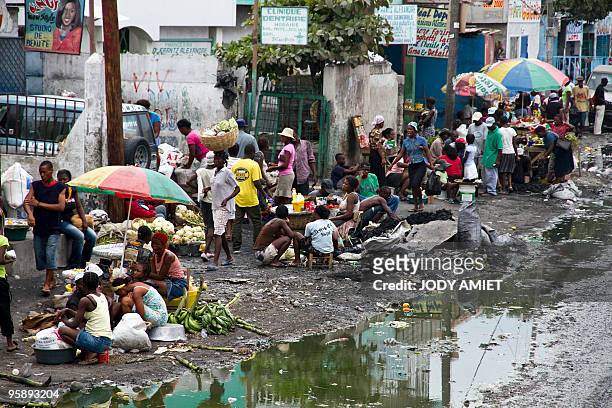 Haitians sell vegetables and converse at the side of a road to in Port-au-Prince on January 19, 2010. Reconstruction of quake-ravaged Haiti could...