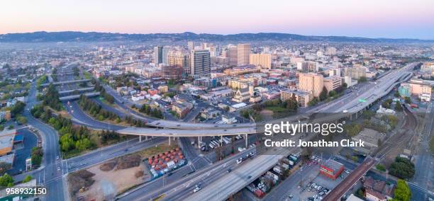 aerial: oakland city skyline at sunset. california, usa - oakland california skyline - fotografias e filmes do acervo