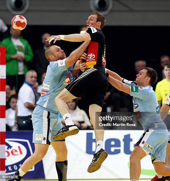 Holger Glandorf of Germany breaks through the defence of Ales Pajovic and Miha Zvizej of Slovenia during the Men's Handball European Championship...