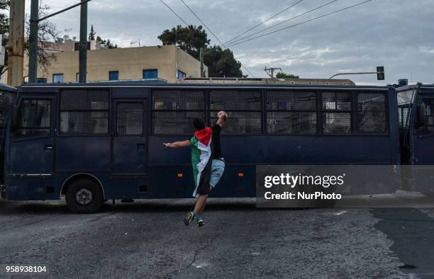 Protesters throw stones at the Israeli embassy during a demonstration in central Athens on May 15, 2018 against the bloodshed along the Gaza border...