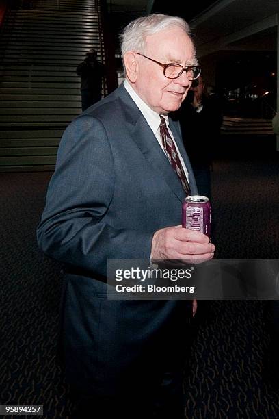 Warren Buffett, chairman and chief executive officer of Berkshire Hathaway Inc., carries a can of Coca-Cola soda as he arrives for a special...