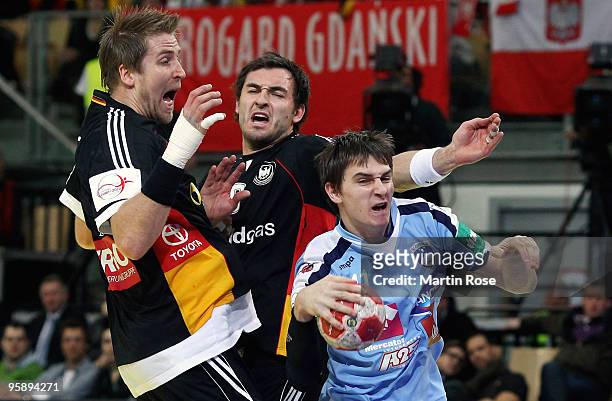 Oliver Roggisch and Michael Mueller of Germany battle for the ball with Sebastian Skube of Slovenia during the Men's Handball European Championship...