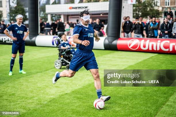 Luis Figo kicks a ball with a mask to feel like a blind player during the EqualGame Match at the Fan Zone ahead of the UEFA Europa League Final...