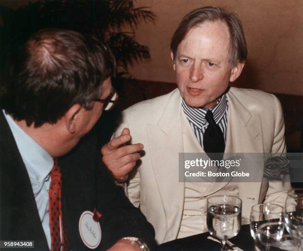 Author Tom Wolfe, right, talks with Harvard Business School Dean John McArthur at International Place in Boston on Feb. 13, 1990. Wolfe was set to...