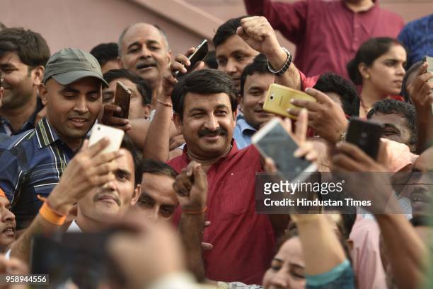 Delhi President Manoj Tiwari clicks selfie with supporters after BJP emerged as the single largest party in Karnataka Assembly elections on May 15,...