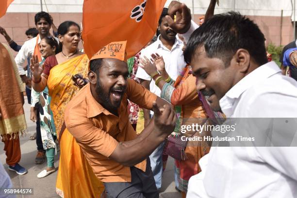 Workers celebrate at party headquarter after BJP emerged as the single largest party in Karnataka Assembly elections on May 15, 2018 in New Delhi,...